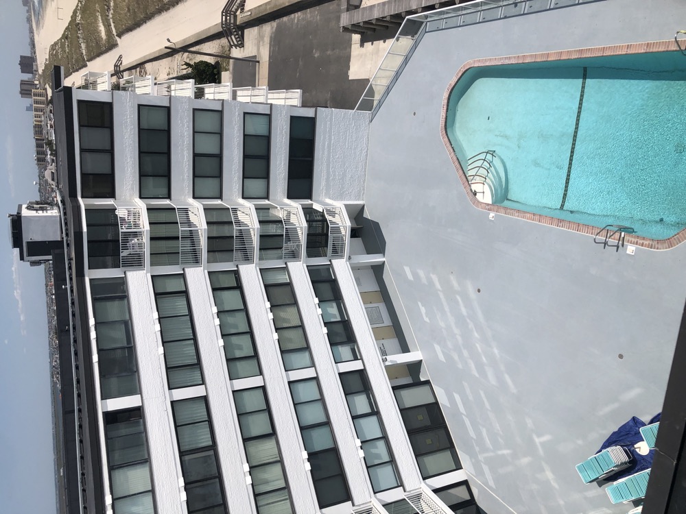 Oceanfront hotel with a freshly coated pool deck and white exterior walls